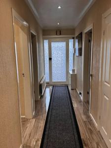 um corredor com uma grande janela e um corredor com um hall de entrada em 230 Councillor Lane em Cheadle