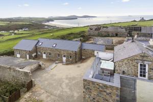 widok z lotu ptaka na stary kamienny dom z widokiem na ocean w obiekcie Awel y Môr - 3 Bedroom Cottage - Whitesands w mieście St David's