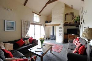 a living room with couches and a coffee table at Upper Porthmawr - 5 Bedroom Cottage - Whitesands in St. Davids