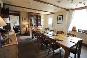a dining room with a large wooden table and chairs at Upper Porthmawr - 5 Bedroom Cottage - Whitesands in St. Davids