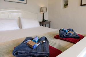 pokój hotelowy z łóżkiem, dwoma ręcznikami i butelką oxidehiba w obiekcie Tan y Garn - 2 Bedroom Cottage - Whitesands w mieście St David's
