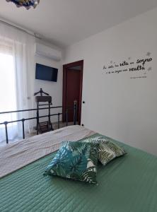 a bedroom with a bed with a pillow on it at Green Rooms - Casa nel verde in Pachino