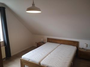 een slaapkamer met een bed met een witte sprei bij Ferienwohnung Glühwürmchen in Hameln