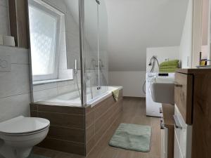 uma casa de banho com uma banheira, um WC e um lavatório. em Dreams im Obergeschoss em Koetz 