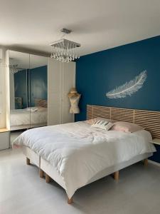 een slaapkamer met een groot bed met een blauwe muur bij Appartement vue sur le lac in Créteil