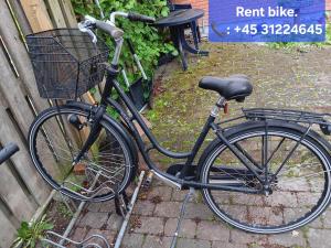 uma bicicleta com um cesto estacionado ao lado de uma cerca em Private room near Copenhagen em Ishoj