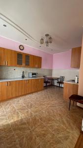 an empty room with a large kitchen with wooden cabinets at ЖК «Нурсая» in Astana