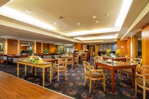 un restaurante con mesas y sillas en una habitación en Waikoloa Hotel, en Taipéi