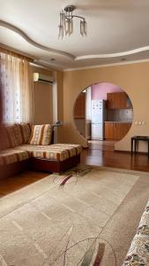 uma sala de estar com um sofá e uma cozinha em ЖК «Нурсая» em Astana