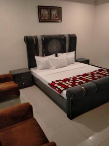 a bedroom with a large bed and a couch at Peridot Vacation Inn, Bahria in Mingora