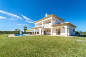 a large white house with a yard and a pool at Filomena Golf Paradise in Guia