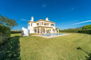 ein großes weißes Haus mit Pool im Hof in der Unterkunft Filomena Golf Paradise in Guia