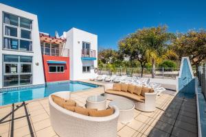 a house with a swimming pool with chairs and a building at Villa Orada in Albufeira