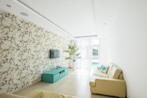 sala de estar con sofá y TV en la pared en Villa Orada, en Albufeira