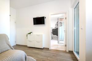 een woonkamer met een bank en een tv aan de muur bij Ojra NEW apartment with seaview in Šibenik