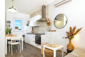 una cucina e un soggiorno con tavolo e specchio di Ojra NEW apartment with seaview a Šibenik