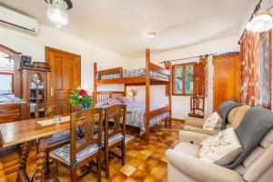 a bedroom with a bunk bed and a dining room at Es Porcho in Deia