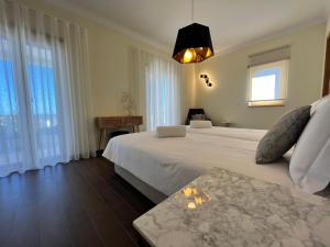 Un dormitorio con una gran cama blanca y ventanas. en Light House Luxury Villa, en Albufeira 27 fotos más