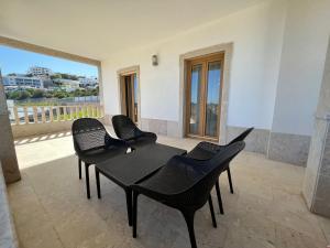 Una mesa y sillas negras en una habitación con vistas. en Light House Luxury Villa, en Albufeira