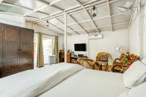 Cp Villa - Rooms with Patio في نيودلهي: غرفة نوم مع سرير وغرفة معيشة