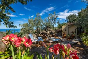 a garden with chairs and flowers in front of a house at Es Porcho in Deia