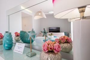 Cette chambre comprend un lit et des vases fleuris. dans l'établissement Marina Design T1, à Albufeira