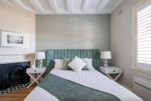a bedroom with a bed with two night stands and a fireplace at Green Stays in Sydney