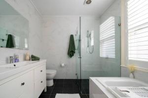 a bathroom with a shower and a toilet and a sink at Green Stays in Sydney +23 photos