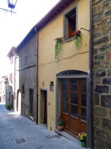 ein Gebäude mit einer Tür und Blumenkästen darauf in der Unterkunft Deliziosa casetta in centro! in Cortona