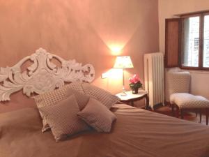 ein Bett mit einem weißen Kopfteil in einem Schlafzimmer in der Unterkunft Deliziosa casetta in centro! in Cortona
