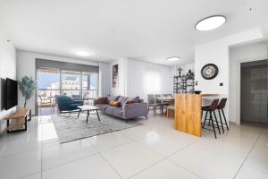 a living room with a couch and a table at Ocean View Oasis with Balcony for families in Ashdod