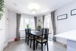 een eetkamer met een zwarte tafel en stoelen bij 4 Bedroom Detached House Ideal for Families and Corporate Stays in Radcliffe on Trent in Burton Joyce