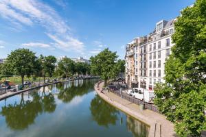 a river in a city with buildings and trees at Timhotel Paris Gare de l'Est in Paris