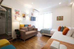 sala de estar con cama, sofá y silla en Sweet Suites Guesthouse close to famous Avenue Liberty, en Lisboa