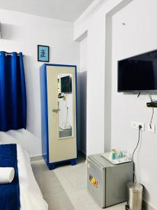 a room with a bed and a mirror and a tv at Smart Stay by Luxe Gachibowli in Hyderabad