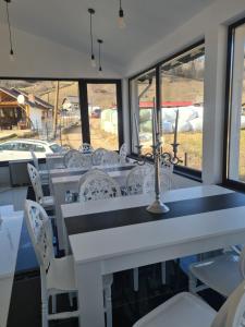 a dining room with white tables and white chairs at Pensiunea WhiteRiver Adults Only-Self check-in in Câmpulung Moldovenesc