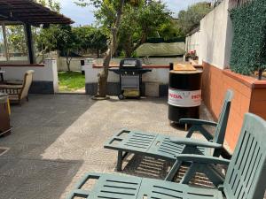 two green chairs and a grill on a patio at Napoli in Villa in Naples