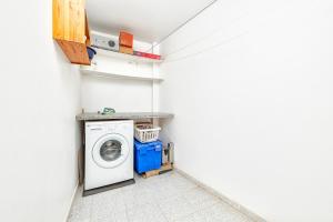 uma lavandaria com máquina de lavar e secar roupa em Apartamento con vistas al mar em Arinaga