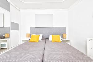 um quarto com uma cama grande e almofadas amarelas em Apartamento con vistas al mar em Arinaga