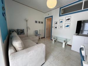 グラードにあるCondominio Ariostoのソファとテレビのあるリビングルーム