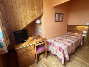 a bedroom with a bed and a desk with a television at Hosteria Gelin de Gajano in Gajano