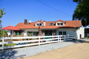 a white fence in front of a house at MAJA Der SpreeGarten in Cottbus