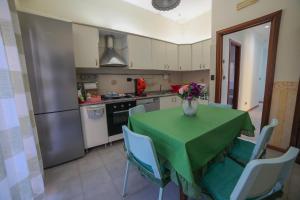 a kitchen with a table with a vase of flowers on it at A casa da Antonio in Belpasso