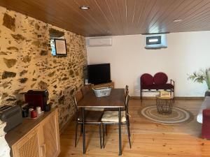 Pokój ze stołem i krzesłami oraz telewizorem w obiekcie Cantinho do Barroco w mieście Penacova