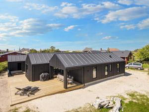 Casa negra con terraza de madera en 5 star holiday home in R m, en Lakolk
