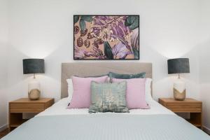 una camera da letto con un letto con due comodini e due lampade di Quinta do Refúgio a Rabo de Peixe Altre 47 foto