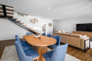 un soggiorno con tavolo in legno e sedie blu di Quinta do Refúgio a Rabo de Peixe