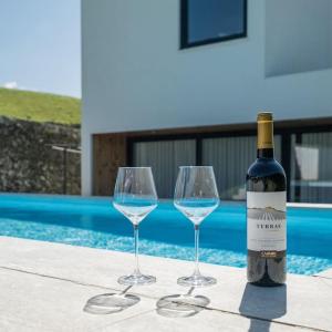una bottiglia di vino e due bicchieri di vino su un tavolo di Quinta do Refúgio a Rabo de Peixe
