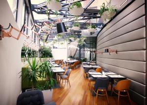 a restaurant with tables and chairs and plants at Hotel Berthelot in Bucharest