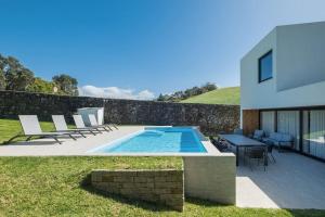 una casa con piscina accanto a un edificio di Quinta do Refúgio a Rabo de Peixe